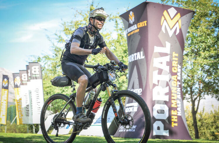 Tall branded yellow and black fabric tower pop up banner behind a man cycling and smiling