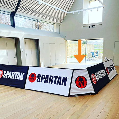 White and black branded rectangular corner banner units advertising Spartan